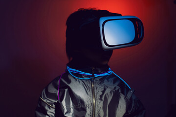 boy child in a silver jacket and glasses virtual reality playing a game. color of cyberpunk