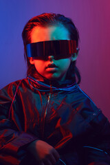 Naklejka premium portrait cyberpunk boy child in vr glasses in blue and red tones with wires on a red background