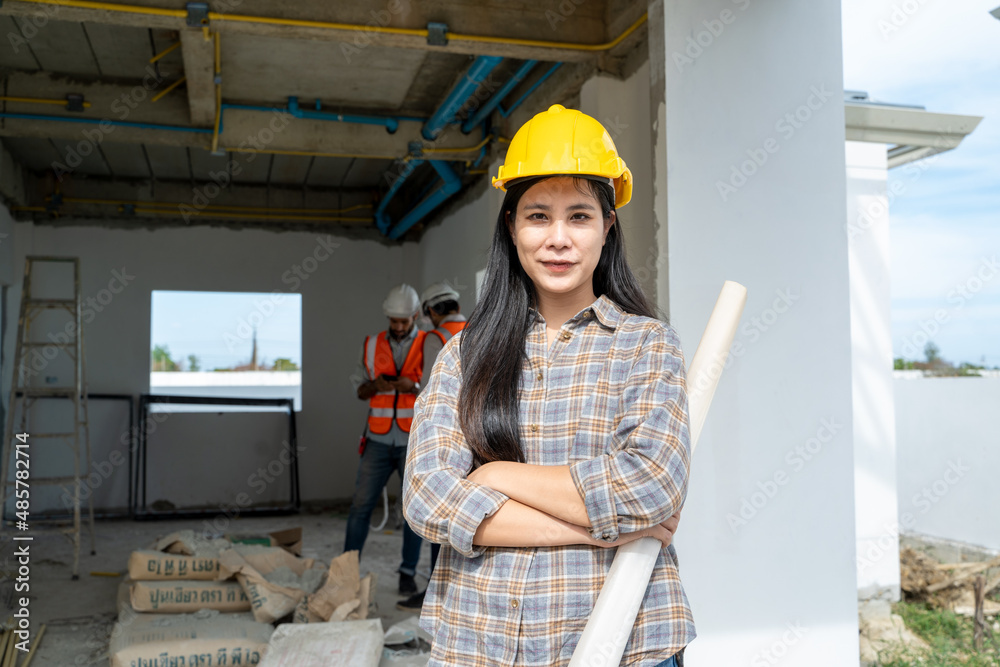 Poster engineers women working with blueprint wearing protective helmet works on the building site.