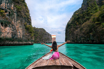 happy Asian woman traveler sit on a long-tailed boat looking at beautiful natural Pileh lagoon...