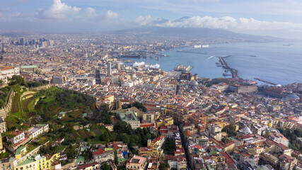 Fototapeta premium Aerial view of the city of Naples and the harbour on a sunny day. The volcano Vesuvius in the background.