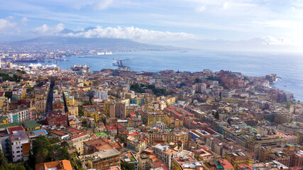 Aerial view of the city of Naples and the harbour on a sunny day. The volcano Vesuvius in the background.