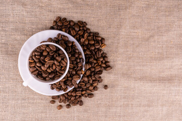Lots of coffee beans in a cup. View from above. Copy space.