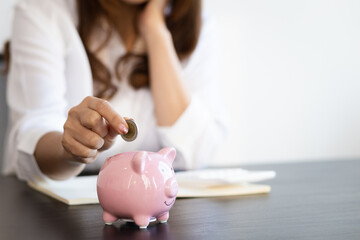 Obraz na płótnie Canvas Woman putting coin in piggy bank. Money saving concept.