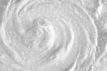 White cream texture. Surface of yogurt and a smoothie of whipped cream smoothie. Background texture of masks and scrubs for face and body. Pearlescent silver surface of the foam.