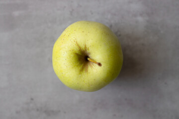 Healthy lifestyle, food and sport concept. Top view of healthy green apple on grey background.