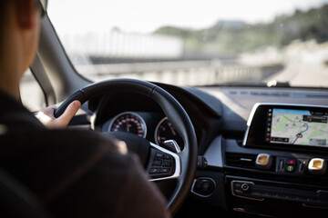 Driver at a steering wheel of a modern car (shallow DOF; color toned image)