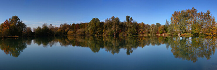 Fototapeta na wymiar Perfect water reflection of a lake in the autumn, fall. Panorama view.