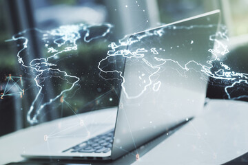 Double exposure of abstract digital world map on laptop background, research and strategy concept