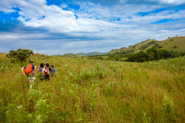 Fototapeta na wymiar Rear view of a group of hikers at the panoramic mountain landscapes at Chyulu Hills, Chyulu Hills National Park, Kenya