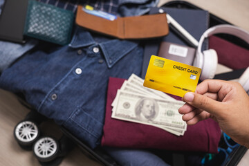 Close up traveler hand man showing credit card payment for travel. Trolley bag and Travel...