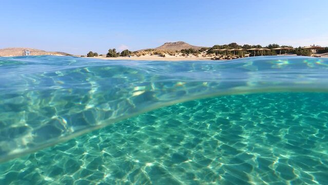 Underwater split video of paradise beach of Simos in island of Elafonisos, Lakonia, Greece