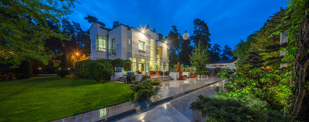 Modern exterior of luxury private house at twilight. View of entrance.