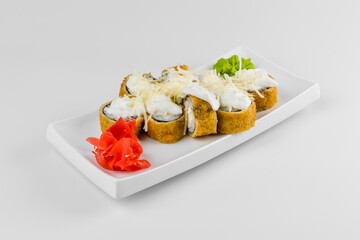Japanese tempura hot sushi roll on white plate and background. Sushi pieces with, eel, cucumber, cream cheese, avocado wrapped in rice with.