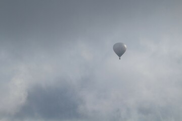 Heissluftballon in den Wolken mit Bergen im Hintergrund