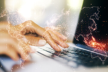 Abstract creative digital world map and hands typing on laptop on background, globalization...