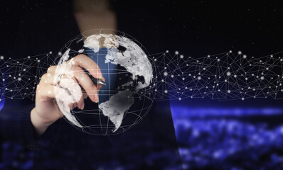 Global network against a dark background. Hand holding digital graphic pen and drawing digital hologram world, earth, map, globe sign on city dark blurred background. GPS map, pin address location.