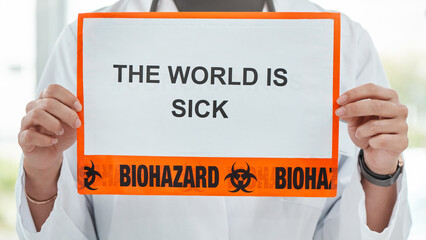 Were doing what we can to heal the world. Shot of a medical practitioner holding up a sign saying THE WORLD IS SICK.