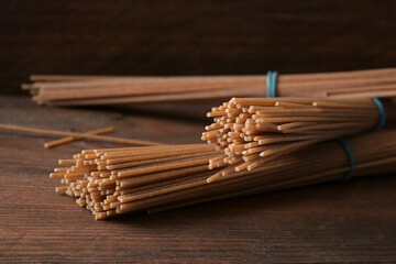Healthy spaghetti from whole grain durum wheat, pasta alternative on a dark wooden background, copy...