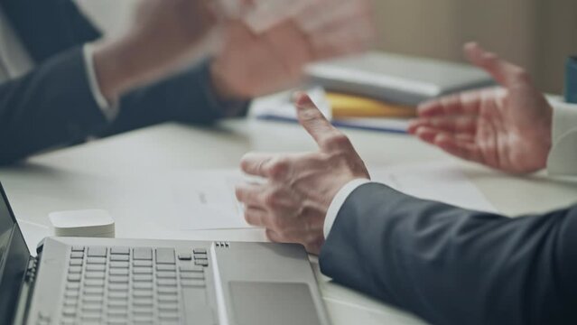 Disappointed businessman arguing with partner and tearing down paper contract