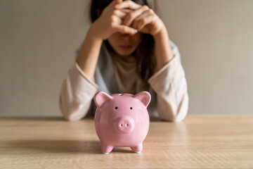 Obraz na płótnie Canvas Sad girl with a piggy bank at home.
