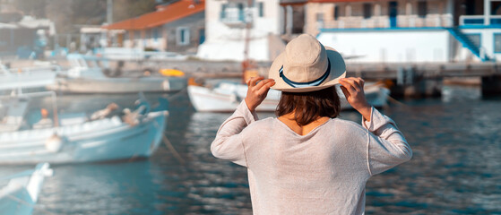 Girl in a hat travels, enjoys beautiful views on the seashore.