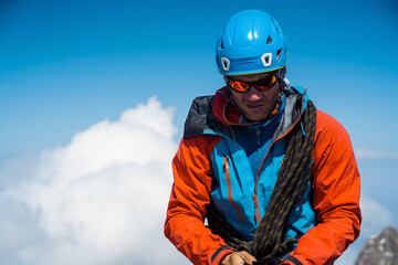 Man with sun glasses is climbing in the mountains.