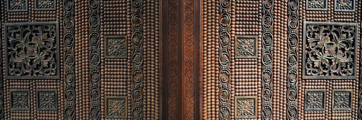 Traditional carving, wooden door with decorative elements.