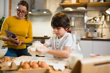 mother and her son preparing food together in kitchen