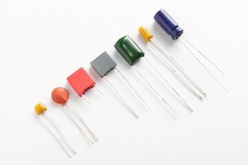 Different types of ceramic, film, tantalum and electrolytic capacitors on white background - obrazy, fototapety, plakaty