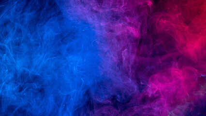 Conceptual image of colorful red and blue color smoke on dark black background.