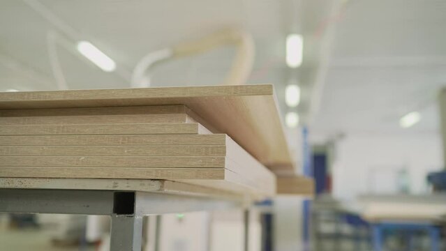 Fragment of a wooden panel made of fiberboard in workshop. Medium Density Fiberboard MDF . Woodworking industry and furniture assembly concept. Furniture manufacture. Fiberboard for furniture assembly