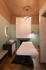 Classical interior of the cosmetology office with a sink, a full-electrical facial beauty bed and chair, a salon stool, a led lamp in a salon. A window curtain down.