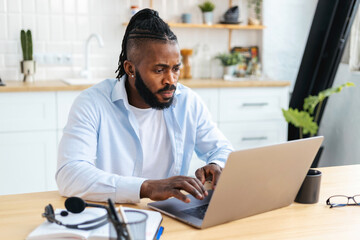 Concentrated African American male student studying remotely at home, online learning. Successful...