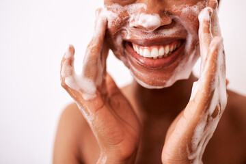 I wash my face twice a day. Studio shot of an unrecognizable woman washing her face against a white background.