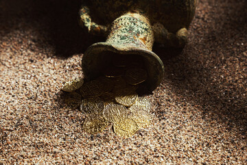 Old treasure in the sand. Treasure discovering concept. Jug with gold coins. Selective focus. - 485806566