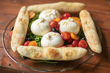 Suluguni sulguni cheese with tomatoes on white background. snack food