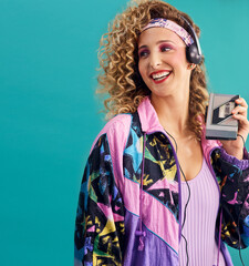 Nothing makes me feel as good as 80s music. Studio shot of a young woman holding a cassette player while dressed in 80s clothing. - obrazy, fototapety, plakaty