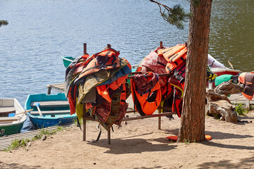 life jackets hanging on a rack on the lake shore