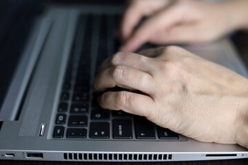 Female hands on laptop keyboard. Woman working at notebook while sitting at the desk