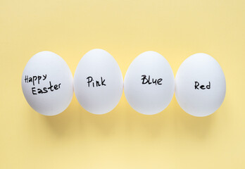 Easter concept. Four eggs with an inscription on a yellow background. Easter layout. A postcard for Easter. Pastel background. layout of the top view