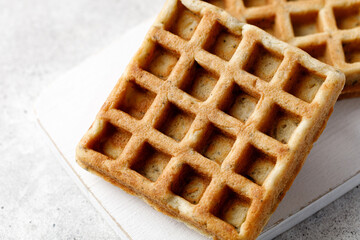 Two delicious waffles close up on white board.