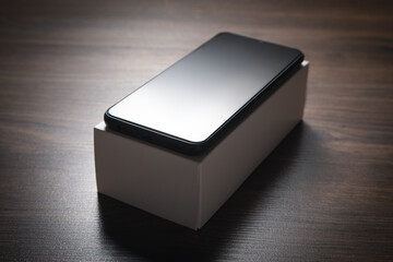 New smartphone on the wooden background.