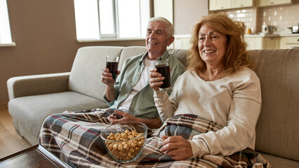 Mature european couple watch TV or movie on sofa