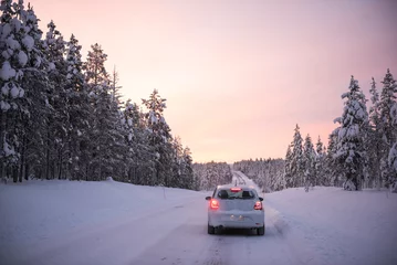 Poster Car driving on icy snow covered roads on a road trip while travelling in Lapland inside the Arctic Circle in Finland © Matthew
