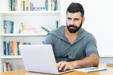 Handsome latin american software programmer with hipster beard at work
