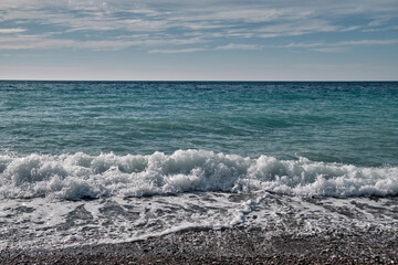 White clouds in  blue sky over blue sea, ocean with sunlight reflection. Sea harmony of white scallops of coastal waves. Sunny skies and calm blue oceans. Bright sea with clouds on horizon.