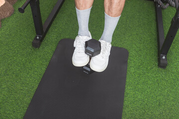 A dumbbell carried between a guy's two feet. Performing weighted hanging leg raises on a pull-up...