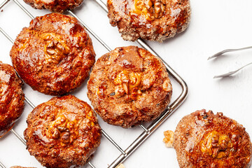 Homemade cookies with walnuts on a grid.