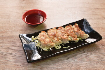 crispy fried Gyoza or Japanese dumpling stuffed mashed pork dipping shoyu sauce on plate